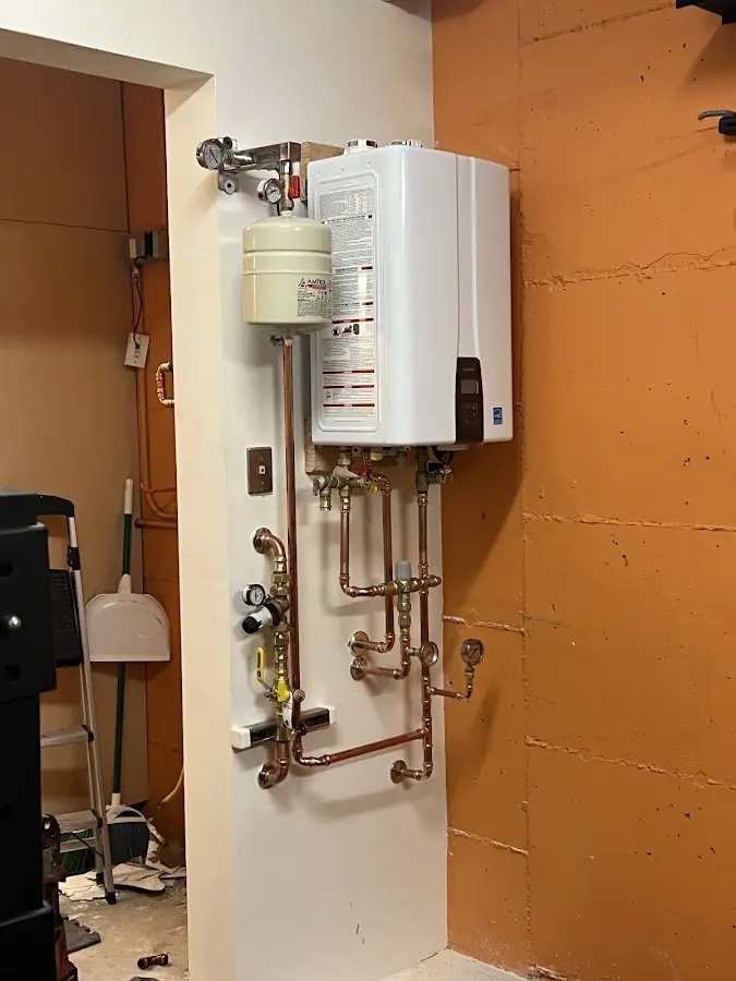 Plumbing technician inspecting water heater connections in Sanger